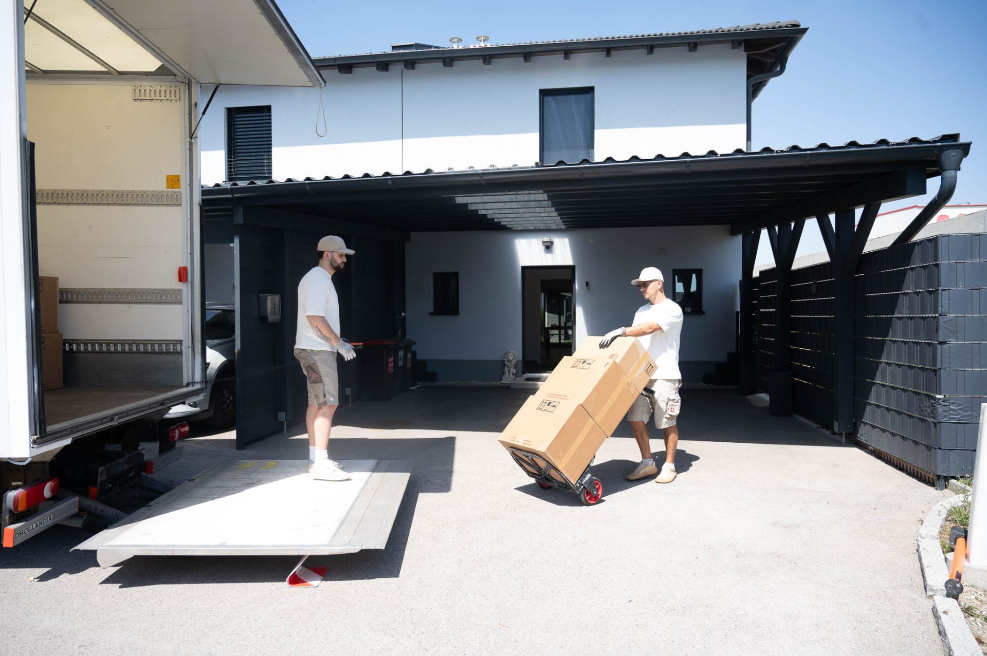 Großer Kudera Umzugs-LKW vor einem Einfamilienhaus mit Carport